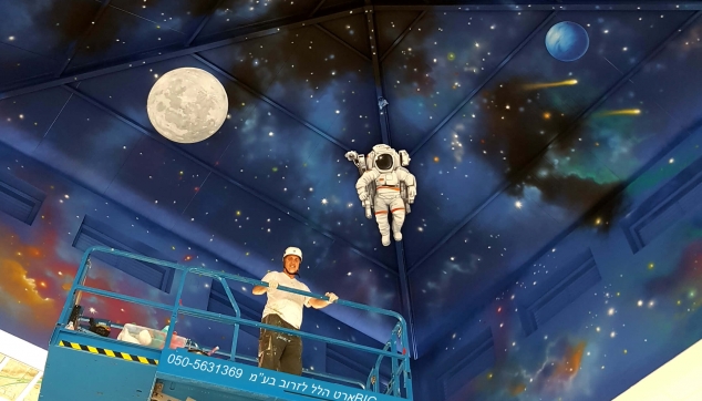 ציור קיר על התקרה של חלל עם אסטרונאוטים